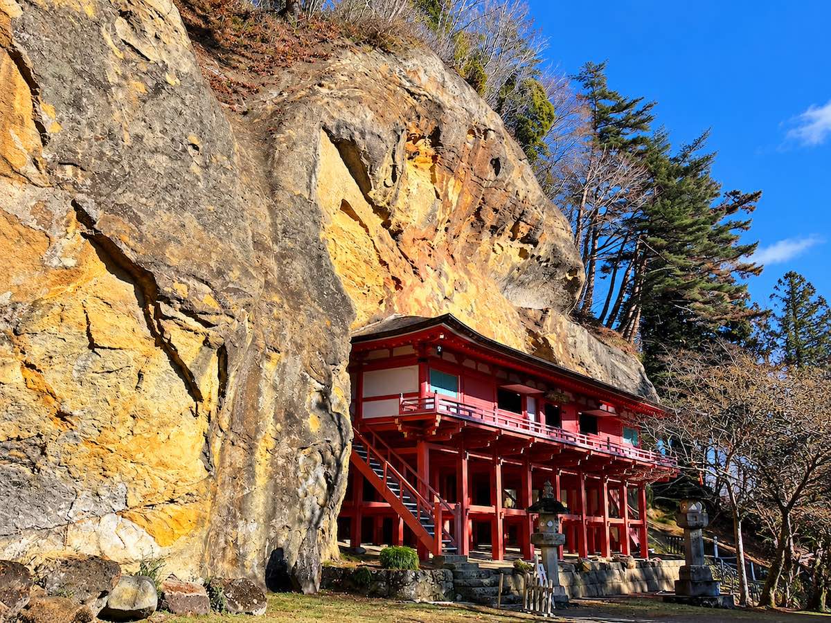 岩手県平泉の達谷窟毘沙門堂と背後にそびえる巨大な岩壁