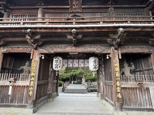 霊山寺の仁王門に安置された金剛力士像と木造の門の彫刻