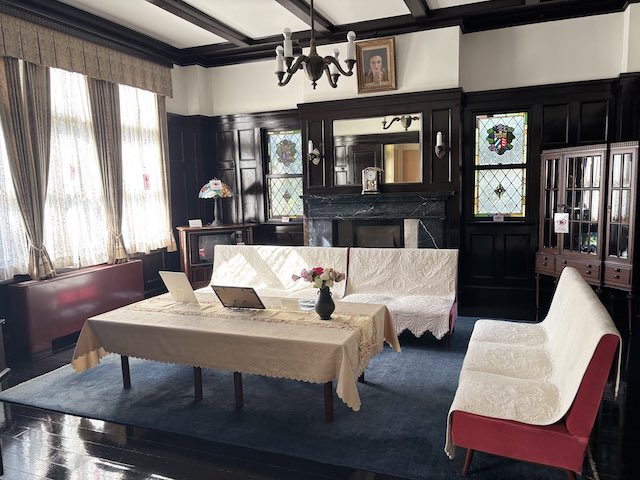 暖炉と濃い色の木製装飾がある鳩山会館の第一応接室