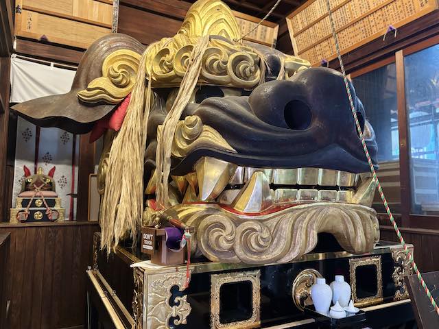 斜めから見た厄除天井大獅子の大きな鼻と牙、金色の装飾