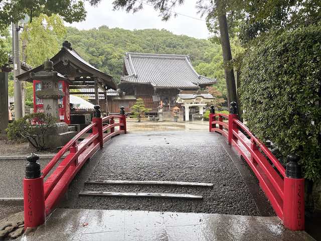 徳島県板野町・金泉寺の朱色の橋と雨に濡れた境内、奥に見える本堂
